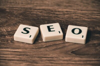 Lettres de Scrabble formant le mot SEO, symbole du référencement d'un site internet