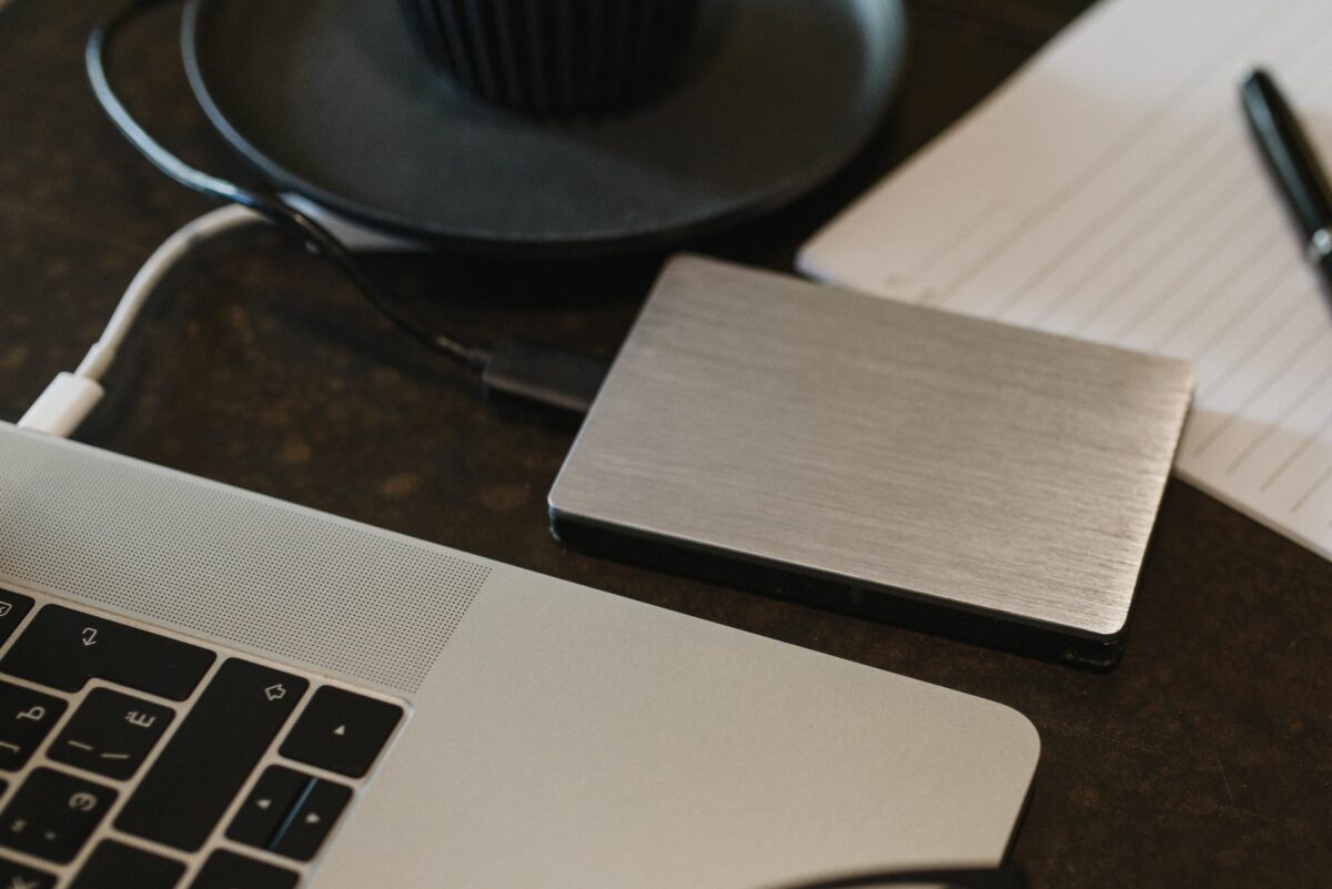 Disque dur externe relié à un ordinateur portable posé sur un bureau